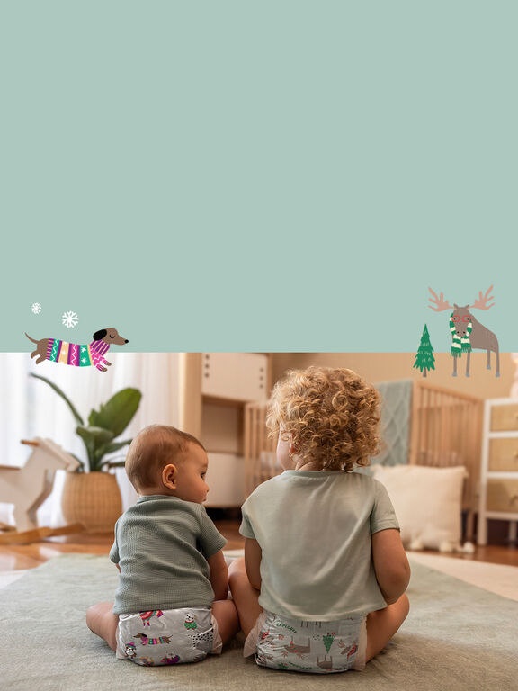 2 toddlers sitting in a playroom wearing Honest Winter themed Diapers