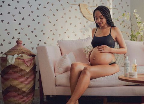 pregnant mama touching her belly in a home setting