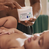 Woman rubbing Healing Head to Toe Ointment on baby